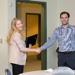 Two people shaking hands and smiling